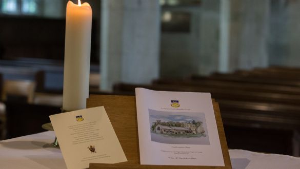 Image of a candle and service sheet for confirmation